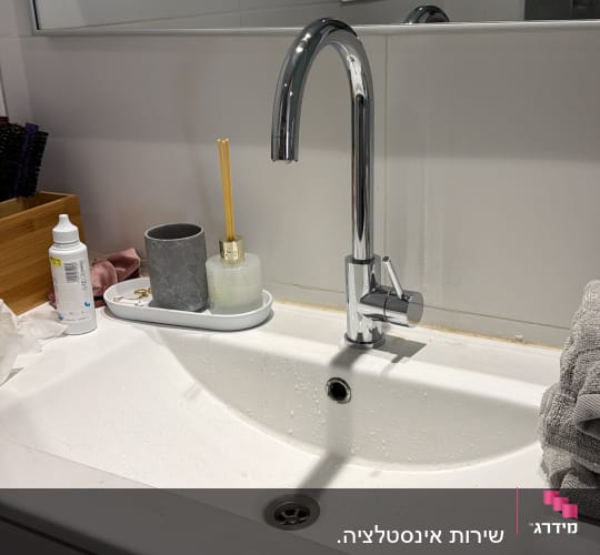 ברז כרום מותקן על כיור רחצה לבן בחדר אמבטיה